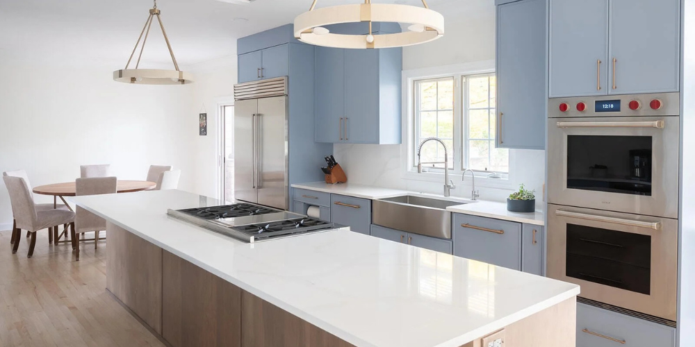 Modern and bright kitchen remodel featuring powder blue cabinets with built in high end ovens and large island | Peacock and Co South Bend, IN