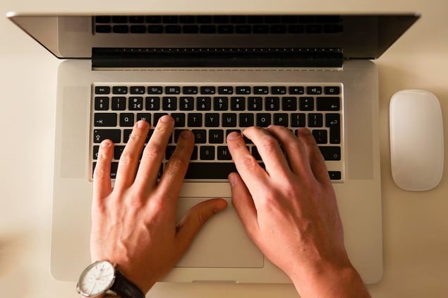 Hands typing over laptop and computer mouse 