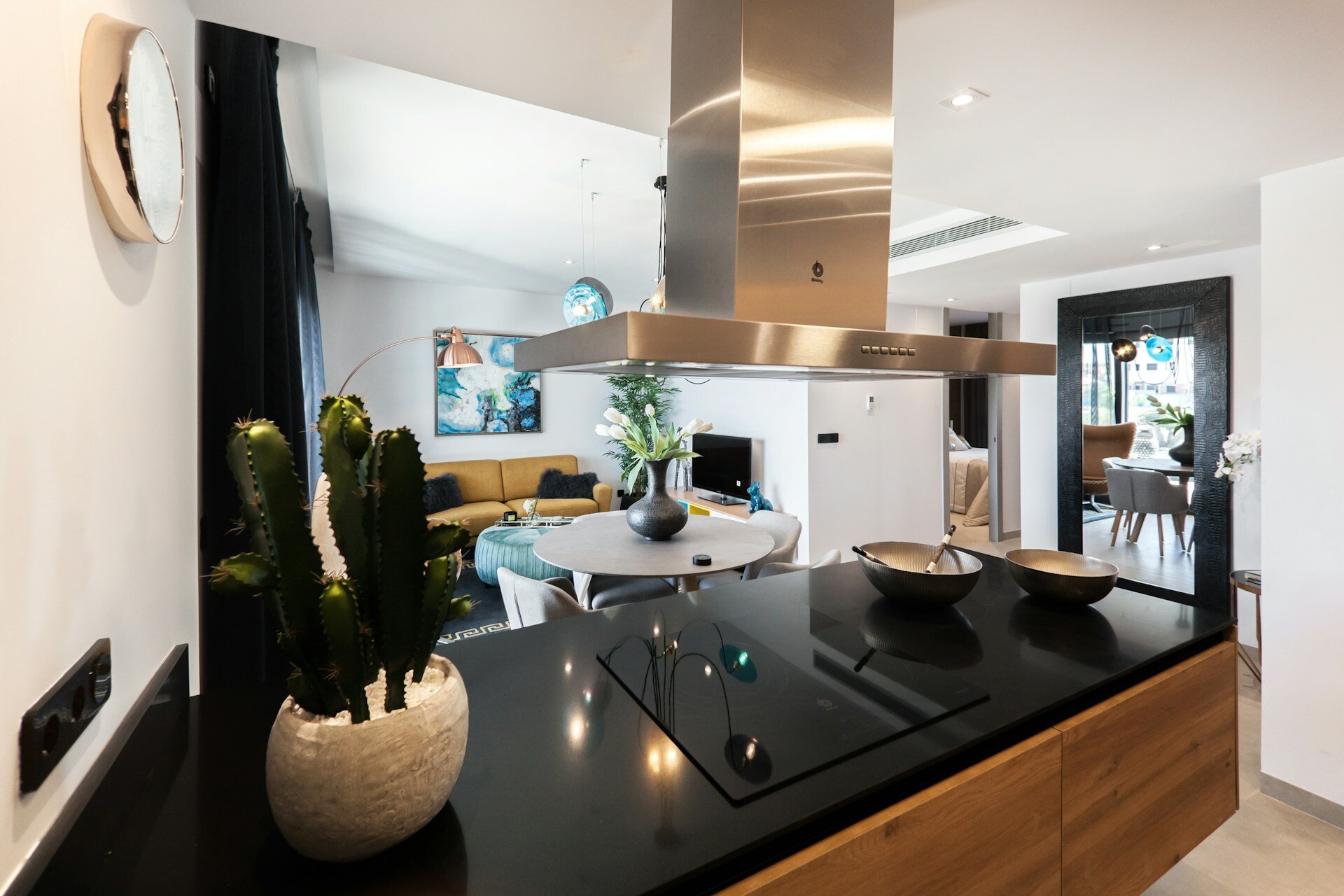 Modern open-concept kitchen with a sleek cooktop, connected to a cozy living area, symbolizing the attention to quality and craftsmanship during remodeling projects