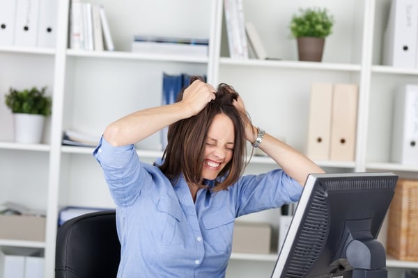 Irritated businesswoman pulling her hair while sitting in office