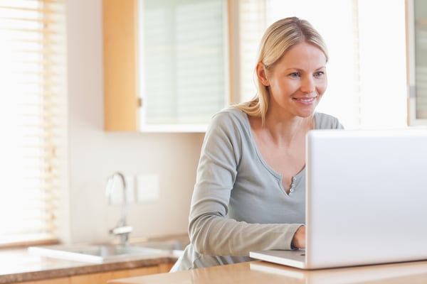 Smiling young woman typing on her laptop