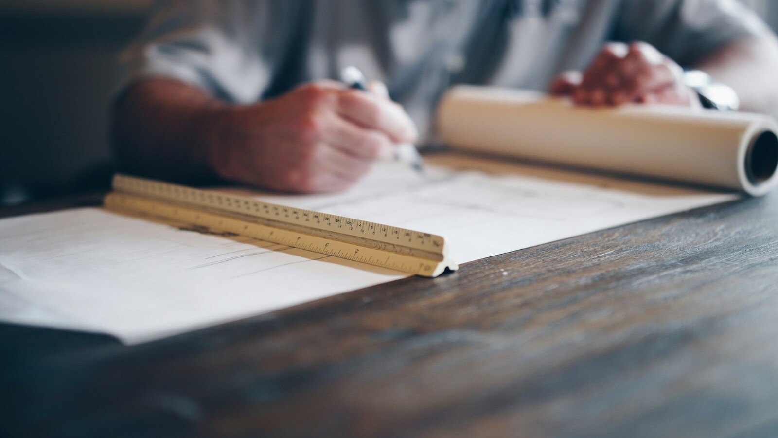 construction magazine and blogs man writing on construction paper with ruler